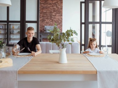 kafkas komik sevimli kardeşler -modern çatı iç yemek odasında ağabeyi ile küçük kız. Aile, yaşam tarzı ve yeme konsepti