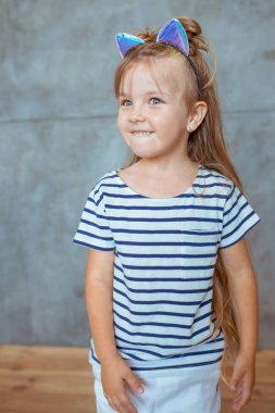 Beyaz, sevimli, tatlı, uzun sarı saçlı, çizgili tişörtlü ve kedi kulaklı bir kız.