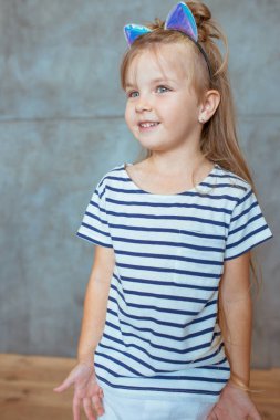 Beyaz, sevimli, tatlı, uzun sarı saçlı, çizgili tişörtlü ve kedi kulaklı bir kız.
