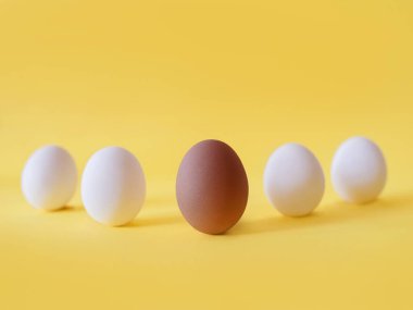 Dark and white eggs on the yellow background. Black lives matter, diversity,  equal rights concept