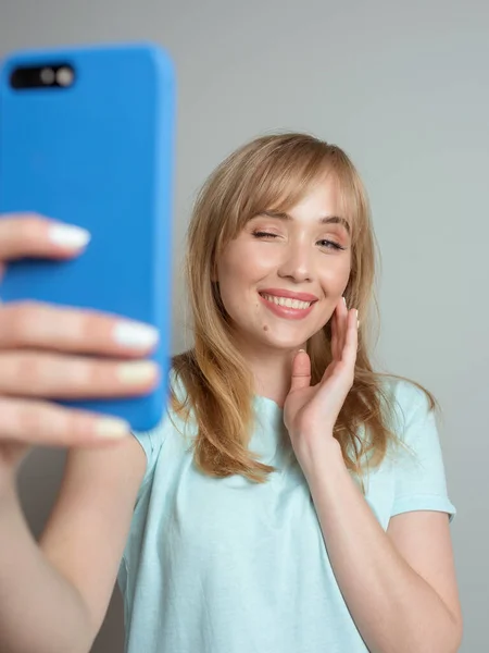 stylish beautiful blonde woman blogger making selfie with her smartphone. Trend, technology, beauty, fashion concept