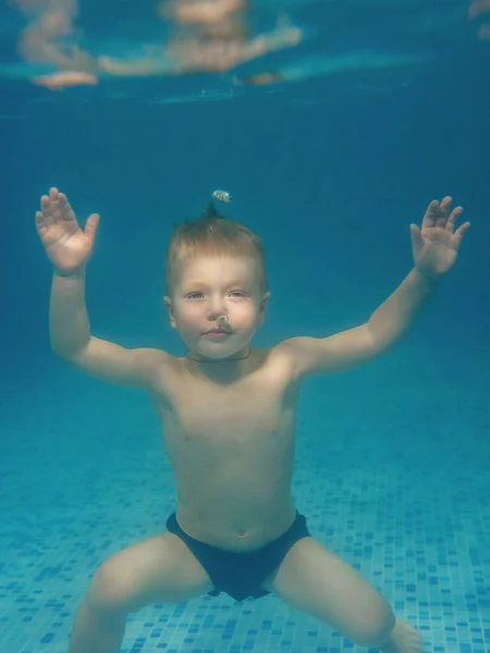 年轻的高加索男孩在游泳池里的水下 — 图库照片