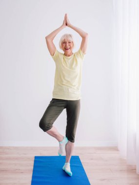 Son sınıf öğrencisi içeride yoga yapıyor. Yaş, spor, yoga konsepti