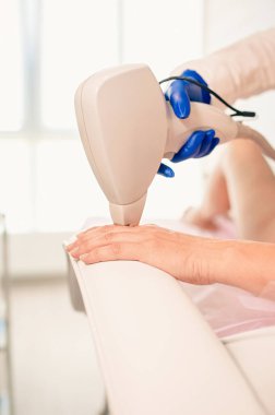 Kozmetologların ofis arka planında lazer tüyleri alınırken pürüzsüz bir kadının eli (parmakları). Güzellik, tedavi, saç temizleme konsepti