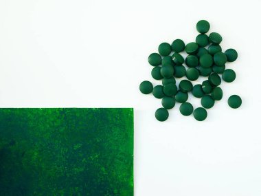 Yemek kaşığı hapları içinde yeşil Hawai spirulinası. Süper yemek, sağlıklı yaşam tarzı, sağlıklı takviyeler, aşçılık konseptinde süper yiyecekler.