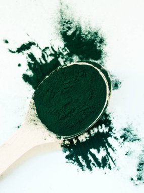 Tahta kaşıkta toz içinde yeşil Hawaii spirulinası. Süper yemek, sağlıklı yaşam tarzı, sağlıklı takviyeler, aşçılık konseptinde süper yiyecekler.