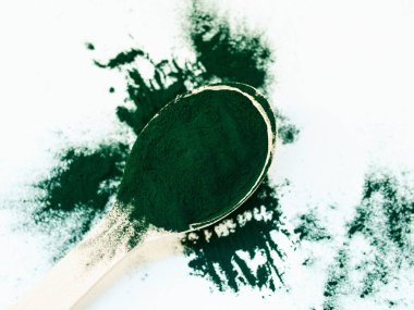 Tahta kaşıkta toz içinde yeşil Hawaii spirulinası. Süper yemek, sağlıklı yaşam tarzı, sağlıklı takviyeler, aşçılık konseptinde süper yiyecekler.