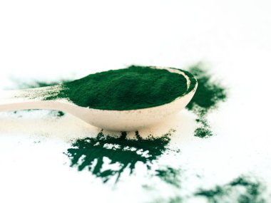 Tahta kaşıkta toz içinde yeşil Hawaii spirulinası. Süper yemek, sağlıklı yaşam tarzı, sağlıklı takviyeler, aşçılık konseptinde süper yiyecekler.