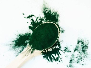 Tahta kaşıkta toz içinde yeşil Hawaii spirulinası. Süper yemek, sağlıklı yaşam tarzı, sağlıklı takviyeler, aşçılık konseptinde süper yiyecekler.