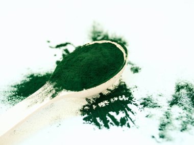 Tahta kaşıkta toz içinde yeşil Hawaii spirulinası. Süper yemek, sağlıklı yaşam tarzı, sağlıklı takviyeler, aşçılık konseptinde süper yiyecekler.