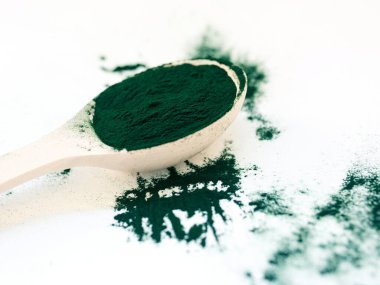 Tahta kaşıkta toz içinde yeşil Hawaii spirulinası. Süper yemek, sağlıklı yaşam tarzı, sağlıklı takviyeler, aşçılık konseptinde süper yiyecekler.