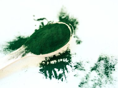 Tahta kaşıkta toz içinde yeşil Hawaii spirulinası. Süper yemek, sağlıklı yaşam tarzı, sağlıklı takviyeler, aşçılık konseptinde süper yiyecekler.