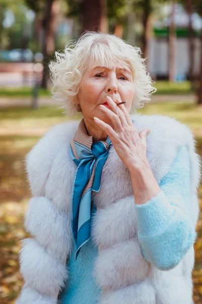 Грустная Модная Пожилая Женщина Седыми Волосами Шубе Открытом Воздухе Курящая — стоковое фото
