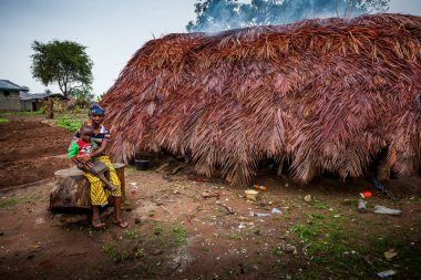 Yongoro, Sierra Leone - 02 Haziran 2013: Batı Afrika, çocuğun yanında köyün önünde Sierra Leone, Freetown başkenti kulübede ile bilinmeyen kadın
