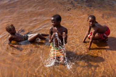 Yongoro, Sierra Leone - 04 Haziran 2013: Batı Afrika, nehir kenarında köyün başkent Freetown, Sierra Leone önünde üç bilinmeyen kız