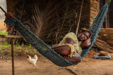 Yongoro, Sierra Leone - 04 Haziran 2013: Batı Afrika, köyün önünde başkent Freetown, Sierra Leone hamakta bilinmeyen kadın kalan