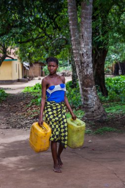 Yongoro, Sierra Leone - 04 Haziran 2013: Batı Afrika, bilinmeyen kadın Sierra Leone, Freetown başkenti önünde köye su dolu kutu taşır
