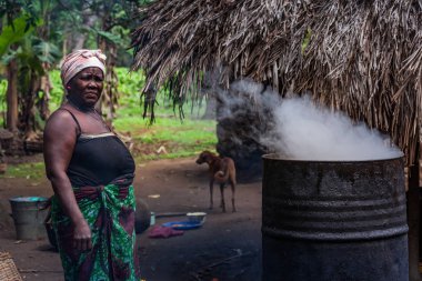 Yongoro, Sierra Leone - 04 Haziran 2013: Batı Afrika, bilinmeyen kadın inşaat üstünde palmiye yağı köyün önünde Sierra Leone, Freetown başkenti dönüşümü