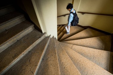 FERRARA, ITALY - May 01, 2018: unknown woman in the staircase of Castello (Castle) Estense, a four towered fortress from the 14th century, Ferrara, E,ilia-Romagna, Italy clipart