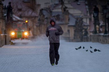 Prague, Çek Cumhuriyeti - 21 Şubat 2013: bilinmeyen runner kar yağışı sırasında Saint Charles bridge uygulamasında