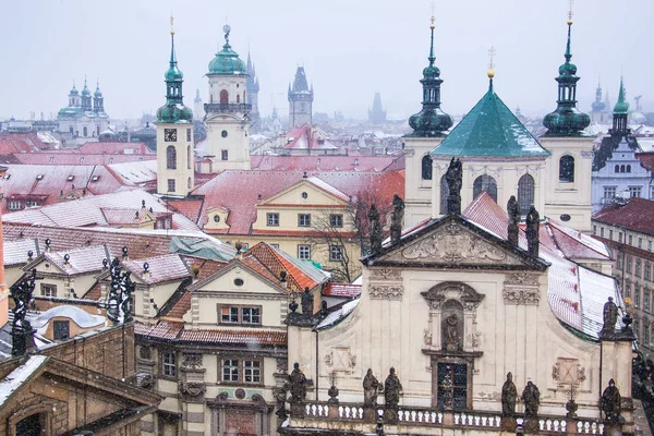 プラハ チェコ共和国 聖サルヴァトール教会の降雪中にセント チャールズ橋からの眺め — ストック写真