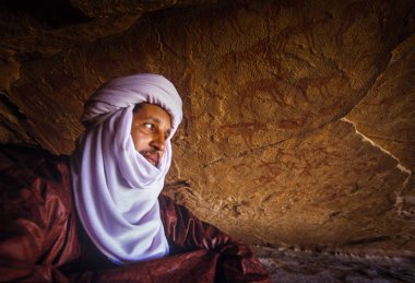 Tamanrasset, Algeria - 7 Ocak 2002: Sahra Çölü, Wilaya Tamanrasset, Hoggar Dağları, Cezayir, Afrika hayvanlarda çizimlerinin antik kaya önemini açıklayan bilinmeyen Touareg kılavuzları