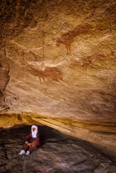 Tamanrasset, Algeria - 7 Ocak 2002: Sahra Çölü, Wilaya Tamanrasset, Hoggar Dağları, Cezayir, Afrika hayvanlarda çizimlerinin antik kaya önemini açıklayan bilinmeyen Touareg kılavuzları