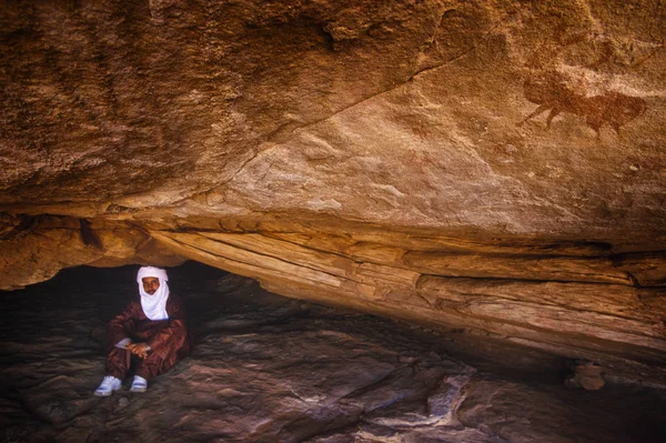 Tamanrasset, Algeria - 7 Ocak 2002: Sahra Çölü, Wilaya Tamanrasset, Hoggar Dağları, Cezayir, Afrika hayvanlarda çizimlerinin antik kaya önemini açıklayan bilinmeyen Touareg kılavuzları