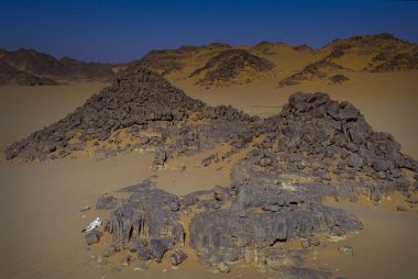 Tassili Najjer, Cezayir - 10 Ocak 2002: kum tepeleri Cezayir Sahara Çölü, Afrika, Tassili Najjer Milli Parkı oturarak bilinmeyen bir adam