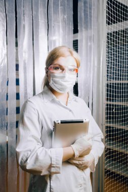 tablet onu daha akıllı çalışma yardımcı olur. Bir kız öğrencinin (kimyager, biyolog) laboratuarda bir tablet ile bir labuatory çalışıyor.