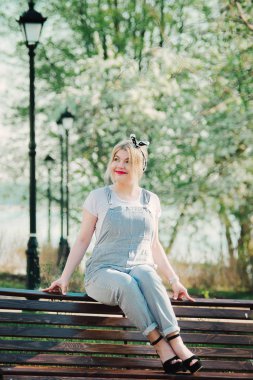 Bir kız eline kiraz çiçekleri bir delikanlı ile bir bankta oturuyor. O doğa hayran ve güneşli gün sahiptir.