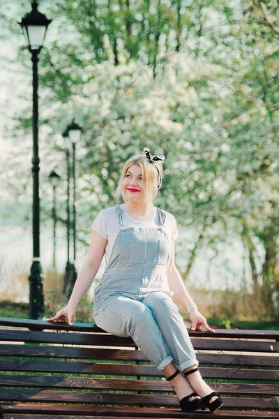 Bir kız eline kiraz çiçekleri bir delikanlı ile bir bankta oturuyor. O doğa hayran ve güneşli gün sahiptir.