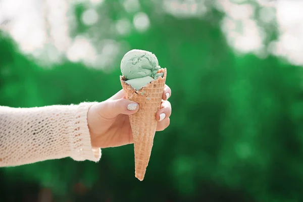 Фісташкове морозиво в руках дівчини. Вафельна чашка і лід c — стокове фото