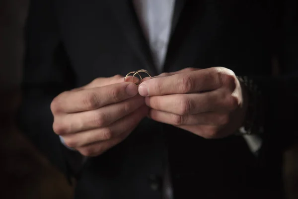 Alyans yakın çekim damat elinde. Yüzük. Karanlık anahtar.