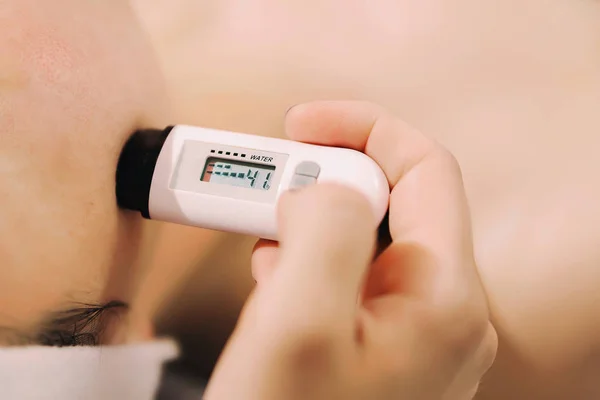 Un dispositivo para medir la saturación de humedad de la piel. Medición de Fotos De Stock Sin Royalties Gratis
