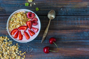 Granola yoğurt meyveleri ile. Çilek ve vişne ile sağlıklı kahvaltı.