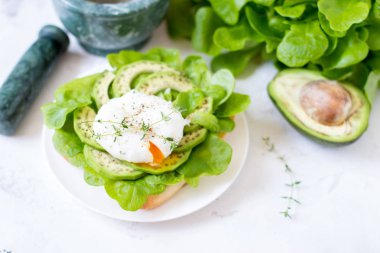 Yumurta-ciabatta ile haşlanmış, avokado ve bebek marul yaprakları.