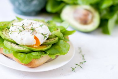 Yumurta-ciabatta ile haşlanmış, avokado ve bebek marul yaprakları.
