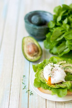 Yumurta-ciabatta ile haşlanmış, avokado ve bebek marul yaprakları.