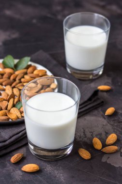 Karanlık bir arka plan cam ve badem fındık, badem sütü.