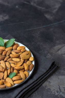 Badem fındık karanlık bir arka plan üzerinde. Organik çiğ badem.