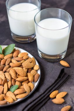 Karanlık bir arka plan cam ve badem fındık, badem sütü.