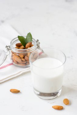 Bir bardak beyaz zemin üzerine badem sütü. Organik vegan süt.