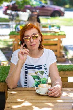 bir kafede kahve içme sokakta yaşlı kadın.