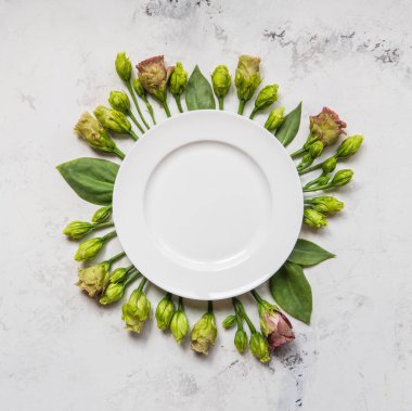 Boş levha çiçekler, üstten görünüm çerçeveli. Plaka üzerinde lisianthus hafif bir arka plan üzerinde.