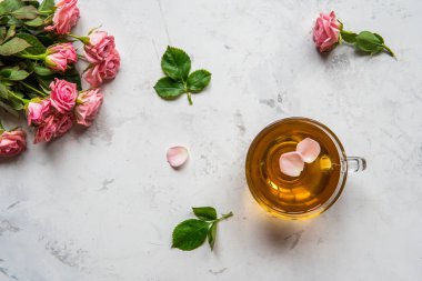 Fincan çay ve bir beyaz arka plan kopya alanı üzerinde ihale pembe güller.