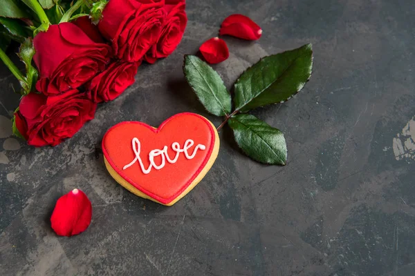 Κόκκινα Τριαντάφυλλα Και Μπισκότο Σχήμα Καρδιάς Κείμενο Αγάπη Σκούρο Φόντο — Φωτογραφία Αρχείου