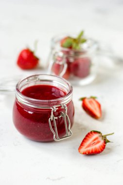 Masadaki cam kavanozda çilek reçeli