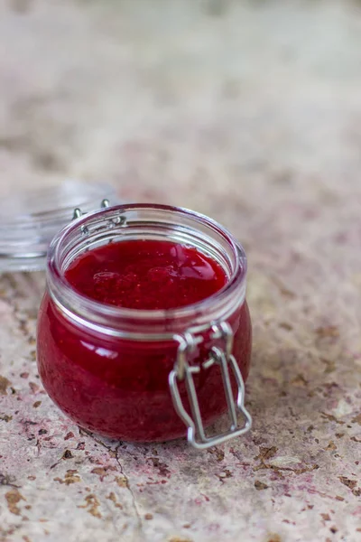 Mermelada de fresa en un frasco de vidrio sobre la mesa — Foto de Stock