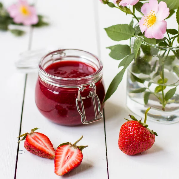 Erdbeermarmelade im Glas auf dem Tisch — Stockfoto